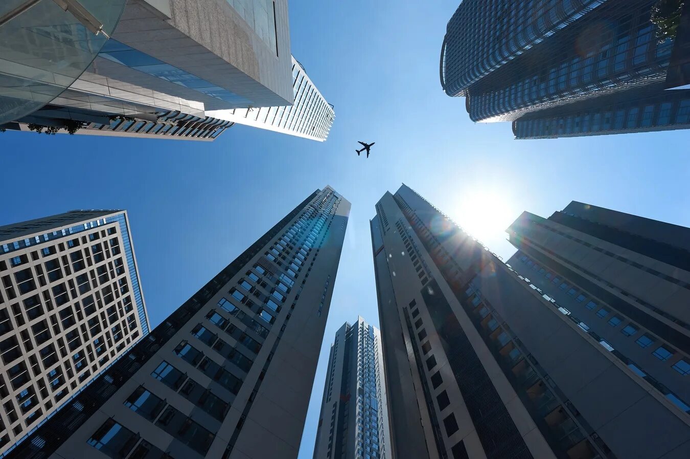 здание самолет. красивый аэропорт. самолет над небоскребами. здание вид снизу. самолет минимализм.