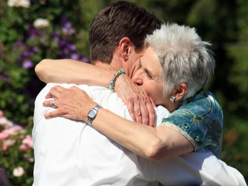 Бабушка обнимает. Мать обнимает сына. Объятия пожилых. Мужчина обнимает мать.