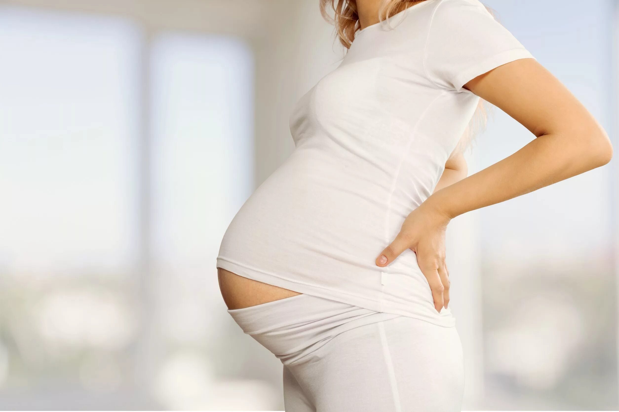 Беременной женщины в белой одежде. Фото беременности. Беременных обманывают
