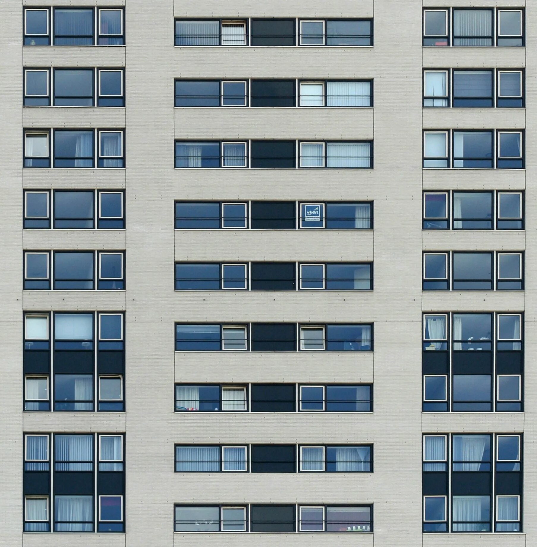 В окнах высотных зданий. Фиброцементные панели EQUITONE Natura n251 антрацит. Текстура фасада здания. Многоэтажное здание. Фасад многоэтажки.