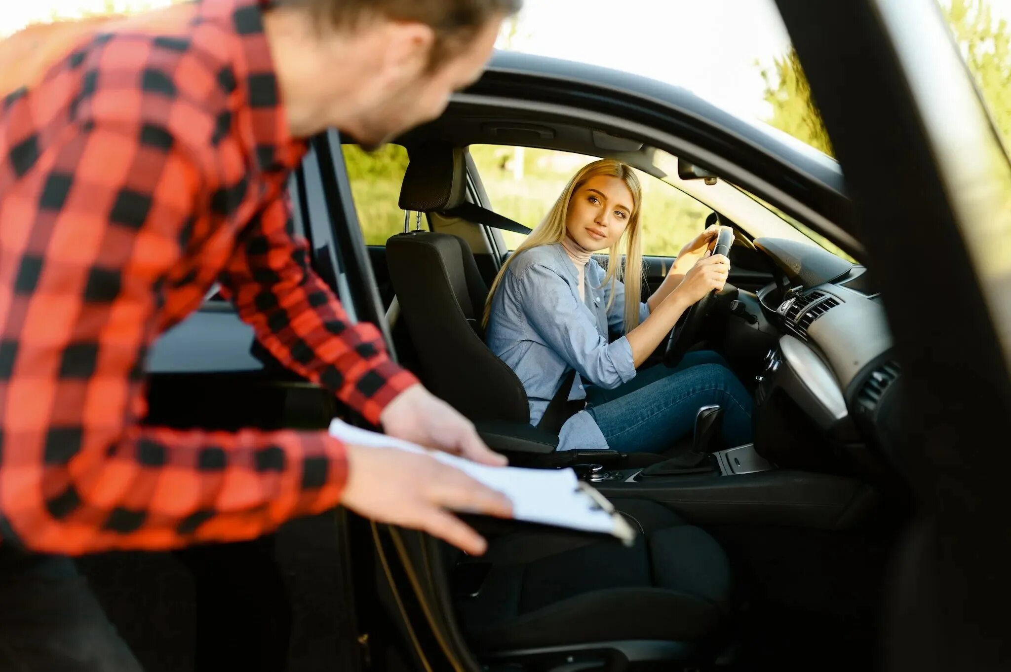 Кресло инструктора по вождению. Белый автомобиль автошкола с мужчиной и женщиной. Парень учит водить машину во сне. Фото девушки и парня на переднем сиденье за рулём машины обучает.