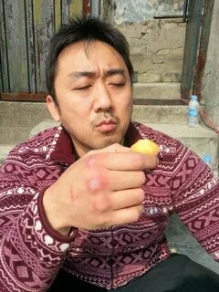 a man sitting down holding something in his hand 