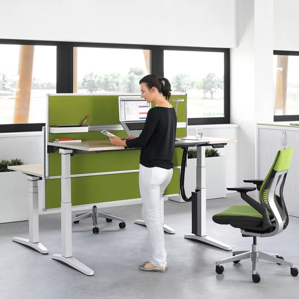 Стоит работать в офисе. Сидит в офисе. Велотренажер под стол. Мужчина в офисе со спины. Стоячий стол.