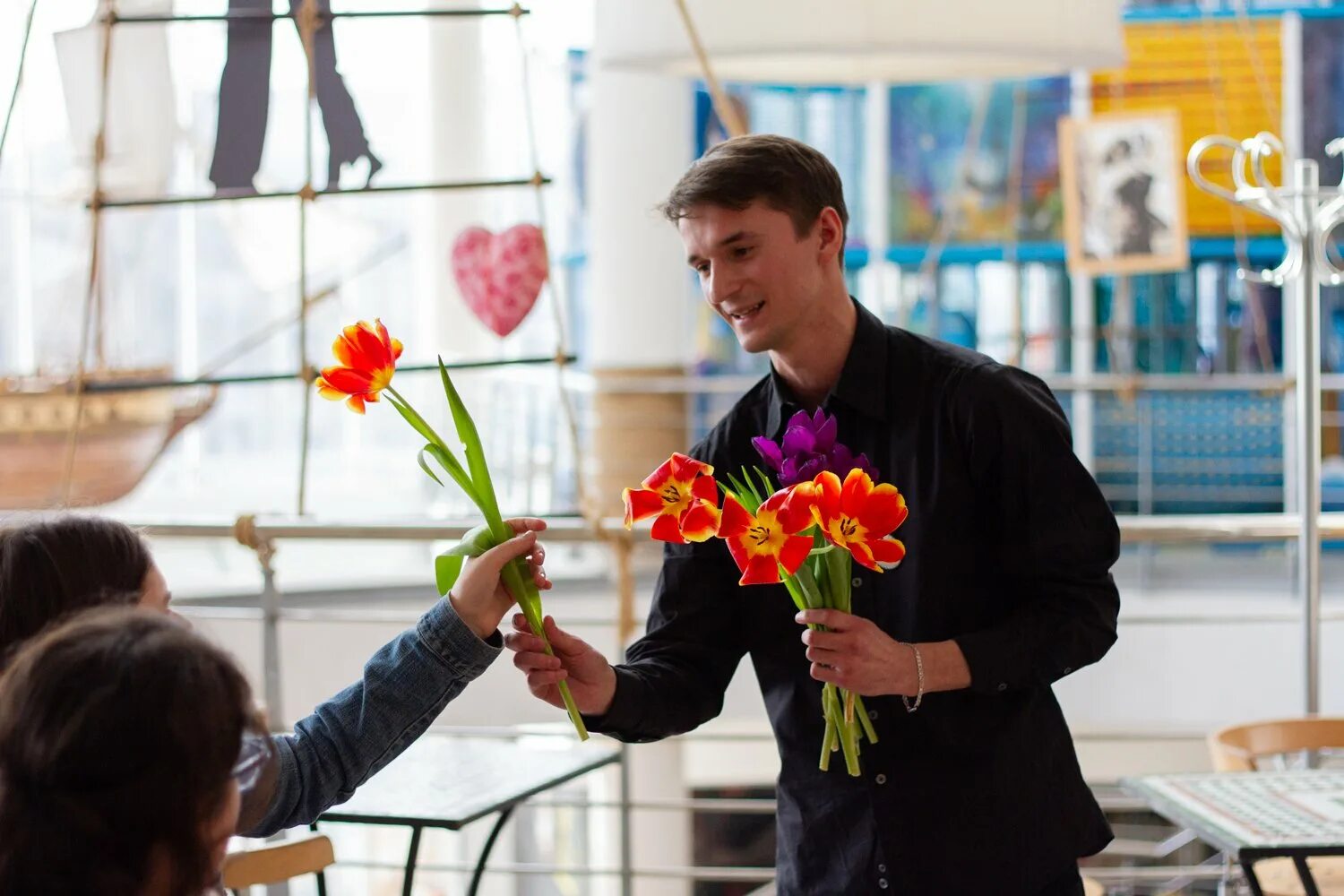 Международный женский день мужчин. Вручение цветов. Дарит цветы. Мужчина дарит цветы. Парень дарит девушке цветы.
