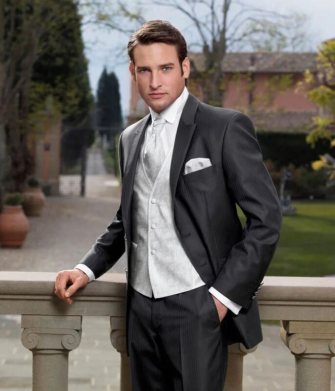 Красивый молодой парень в костюме. Жених бизнесмен. Картинки мужчина держит галстук. Шикарный мужской костюм. Фотосессия жениха.