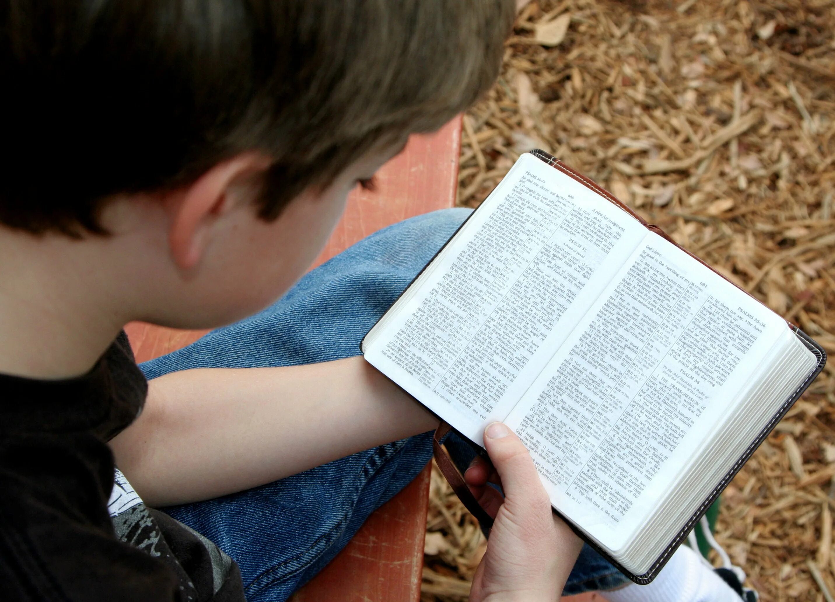 Читаем библию. Чтение Библии. Человек с Библией в руках. Человек читает Библию. Подросток с Библией.