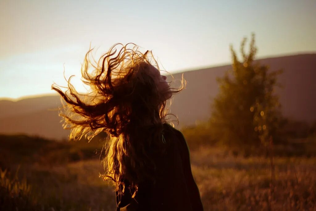 Волосы на ветру со спины. Рыжие волосы на ветру. Кудрявые волосы на ветру. Кудрявая девушка со спины.