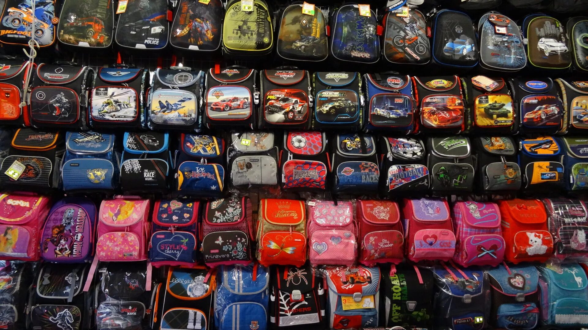 Много портфель. Много рюкзаков. Рюкзаки в ассортименте. Рюкзаки для школы много. Куча рюкзаков школьных.