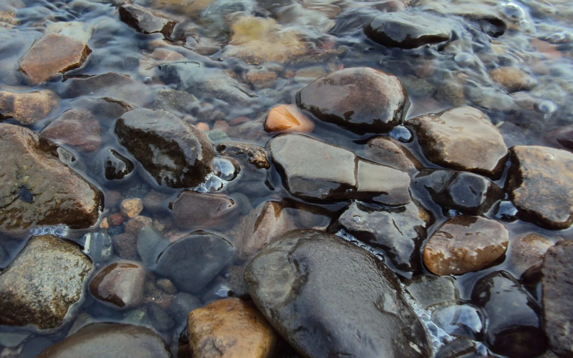 Галька в воде. Камни под водой. Мокрый камень. Камни в прозрачной воде.