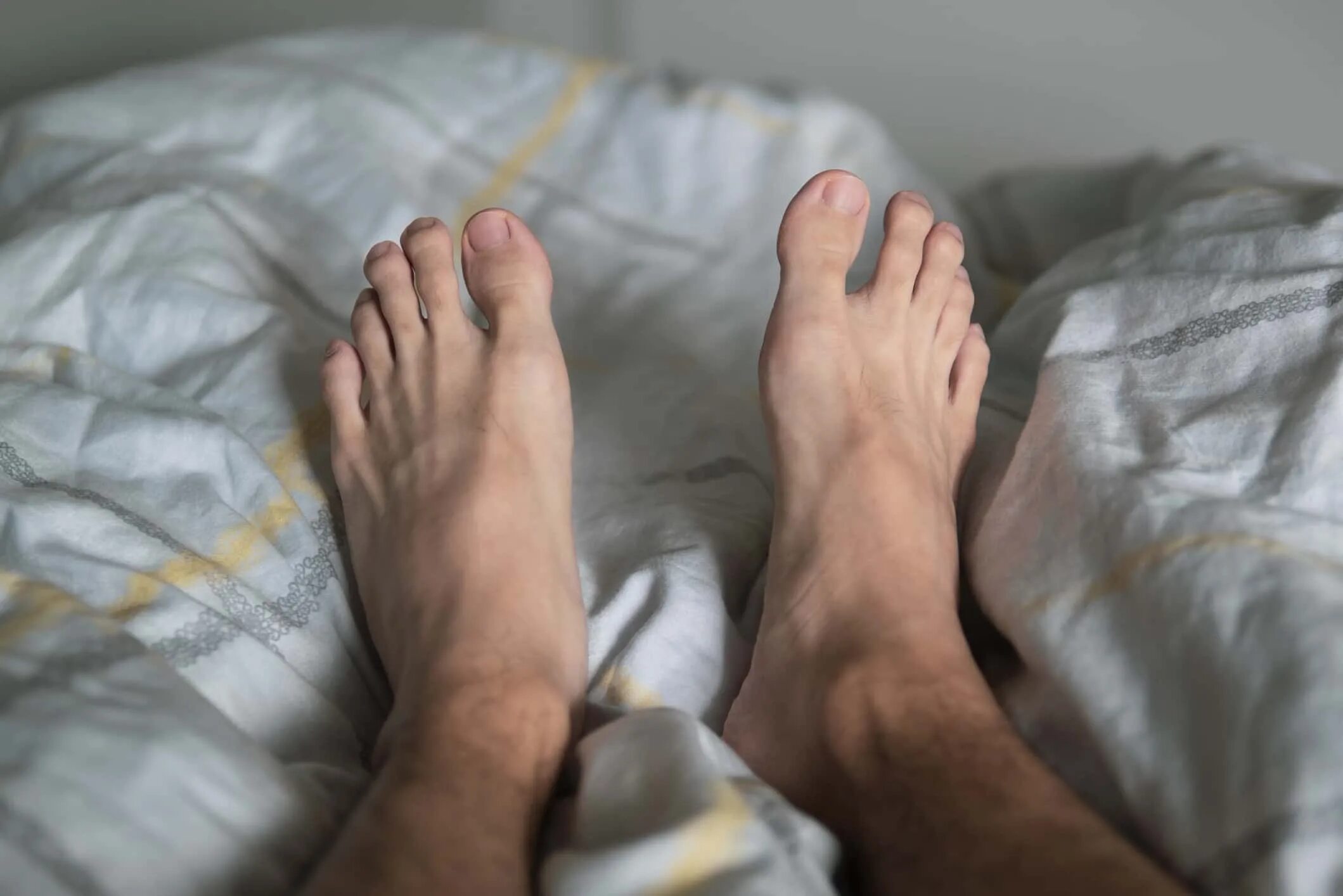 Сильно дергает ноги. Мужские ноги на кровати. Мужские ноги в постели. Мужские ноги Наткровати.