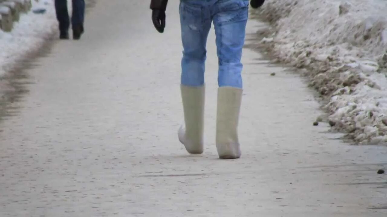 Зима шагает. Люди в валенках. Ноги в валенках. Валенки зима. Шагающий человек в валенках.