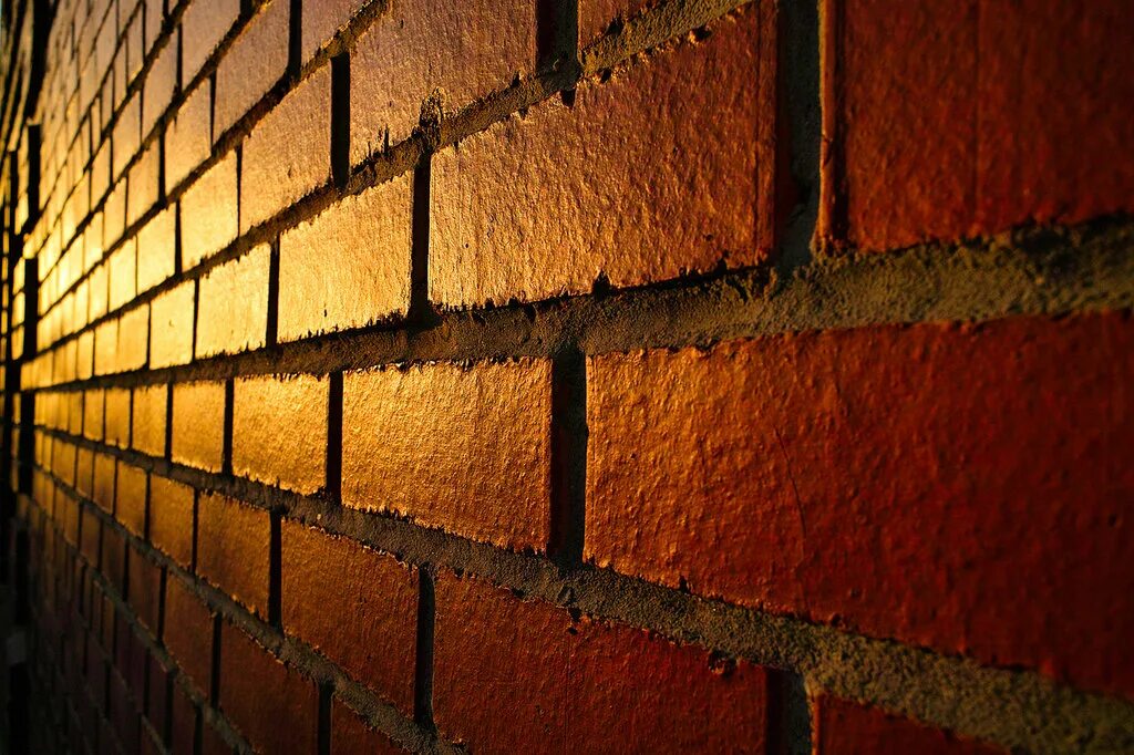 облупившаяся штукатурка. разрушенная стена. кирпичная стена с подсветкой. разрушение кирпичной кладки. кирпичная стена.