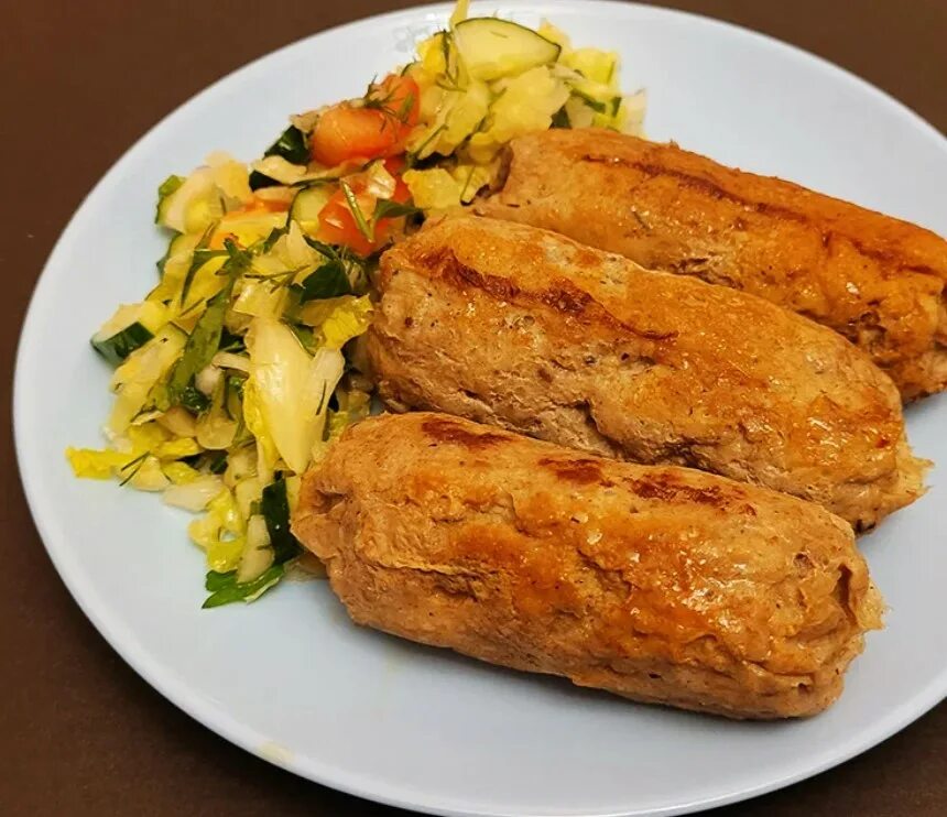 мясной рулет в пергаментной бумаге. колбаски в пергаменте. фарш завернутый в тесто и обжаренный на сковородке. колбаса в пергаменте. фарш в пергаменте.