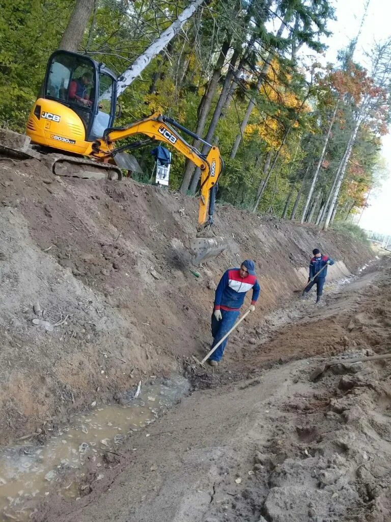 Выполнение земельных работ. Экскаватор копает. Строительный участок. Земляных работ геодезия. Выемка грунта.