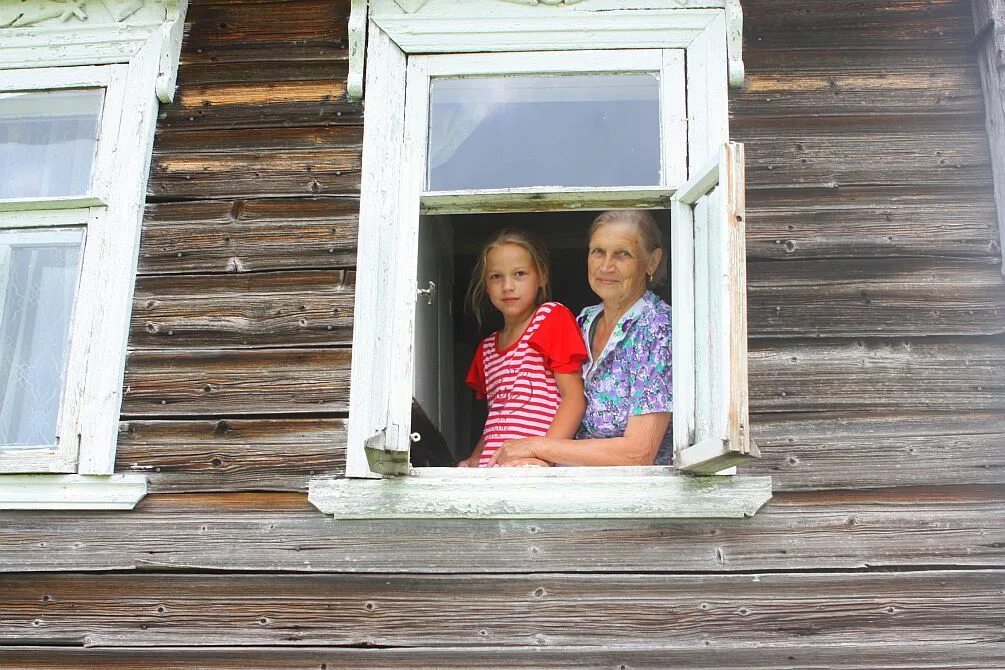 Внучка приехала к дедушке. Девушка в окне деревенского дома. Бабушка у окна в деревне. Девочка в деревне у бабушки. Девочка у окна в деревне.