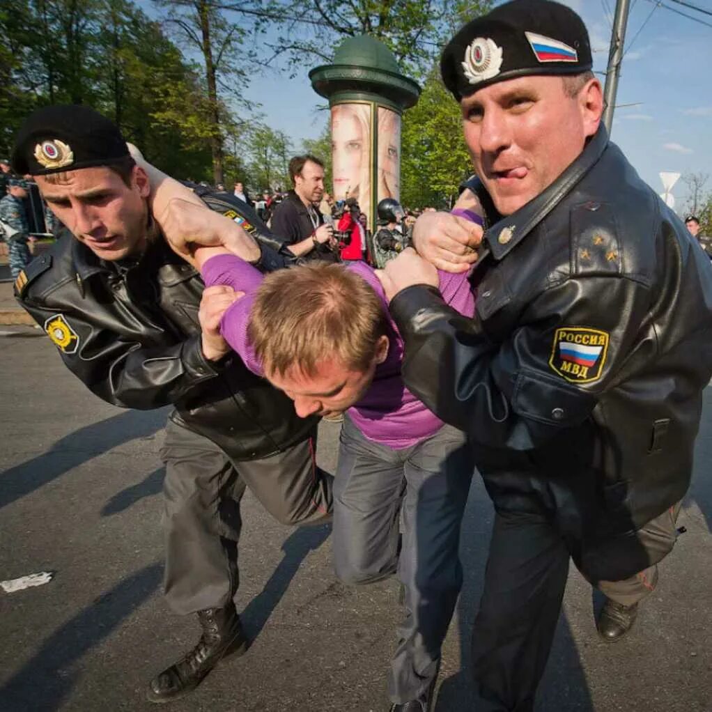 Полиция скручивает человека. Бьют омон