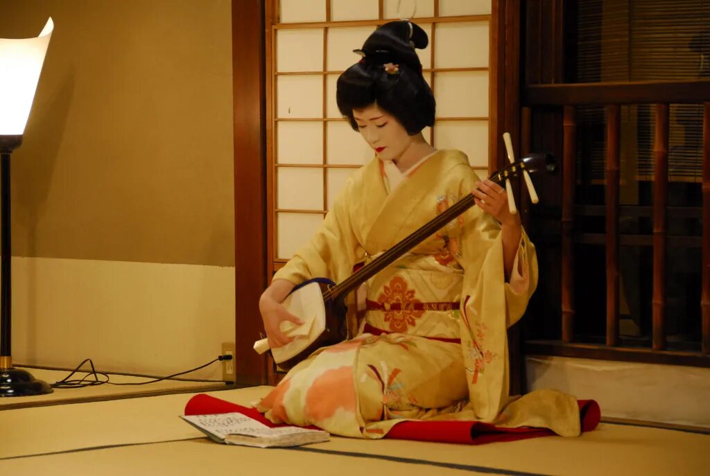 Японская трехструнная лютня с длинной шейкой. Гейша с сямисэном. Гейши в Японии с сямисэном. Сямисэн в Японии. Сямисэн музыкальный инструмент.