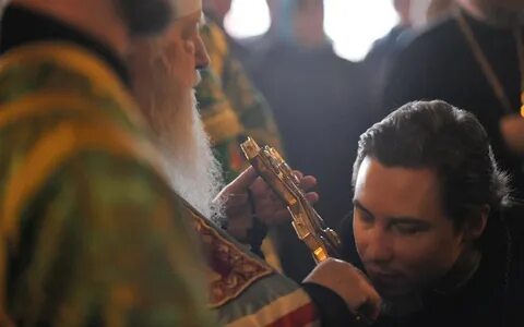 Целует руку священнику
