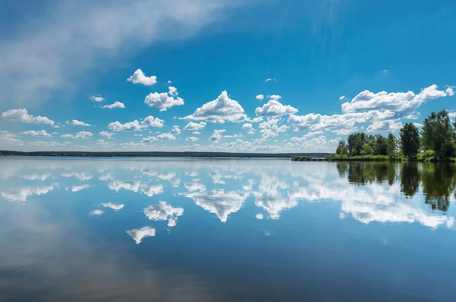 Гладкое озеро. Небо в отражении. Отражение неба в воде. Отражение облаков в воде.