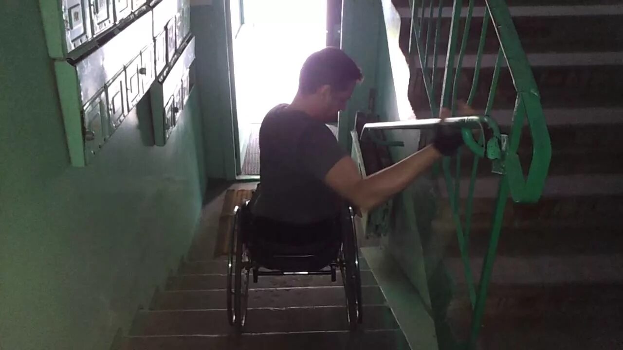 Коляска для спуска по лестнице. Спуск инвалидной коляски по лестнице. инвалидная коляска в подъезде. спуск инвалида по лестнице в коляске. коляска для спуска инвалидов по ступенькам.