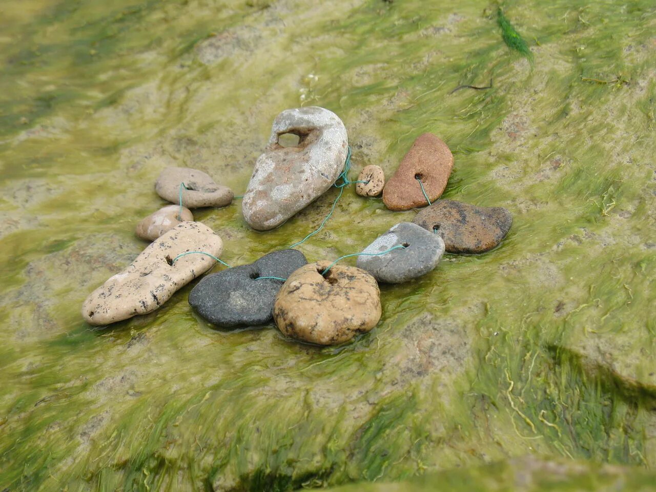 Камень с природным отверстием. Камни найденные в реках. Добыча драгоценных камней в речке. Голодные камни рейн. Камни в природе.