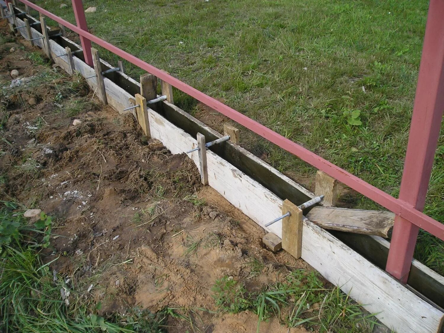 Опалубка для ленты забора. Опалубка для ленточного фундамента забора. Опалубка под ленточный фундамент под забор. Опалубка для забора. Опалубка под фундамент под забор.