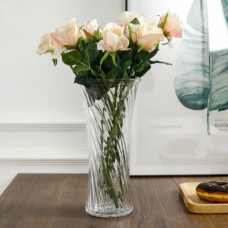 The cocktail tables will have clear glass bud vases with ivory spray roses Weddi