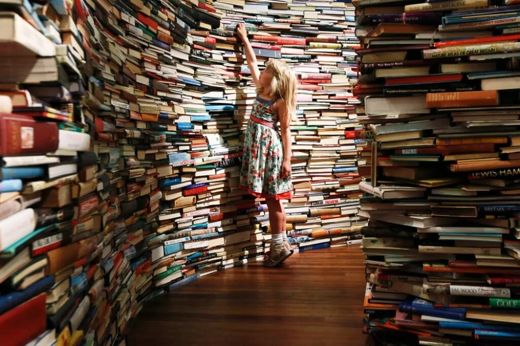 Много книг. Человек с книжкой в руках. Люди в библиотеке. Читатель огромный. Читатели в библиотеке.