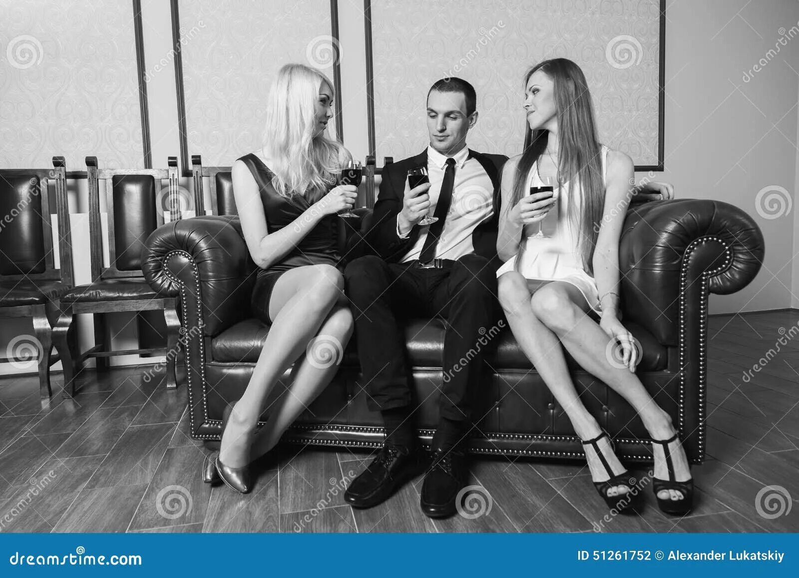 Девушка и 2 мужчины видео. Две девушки сидят. Две девушки сидят на мужчине. Мужчина в костюме с двумя девушками. Фотосессия две девушки и один парень.