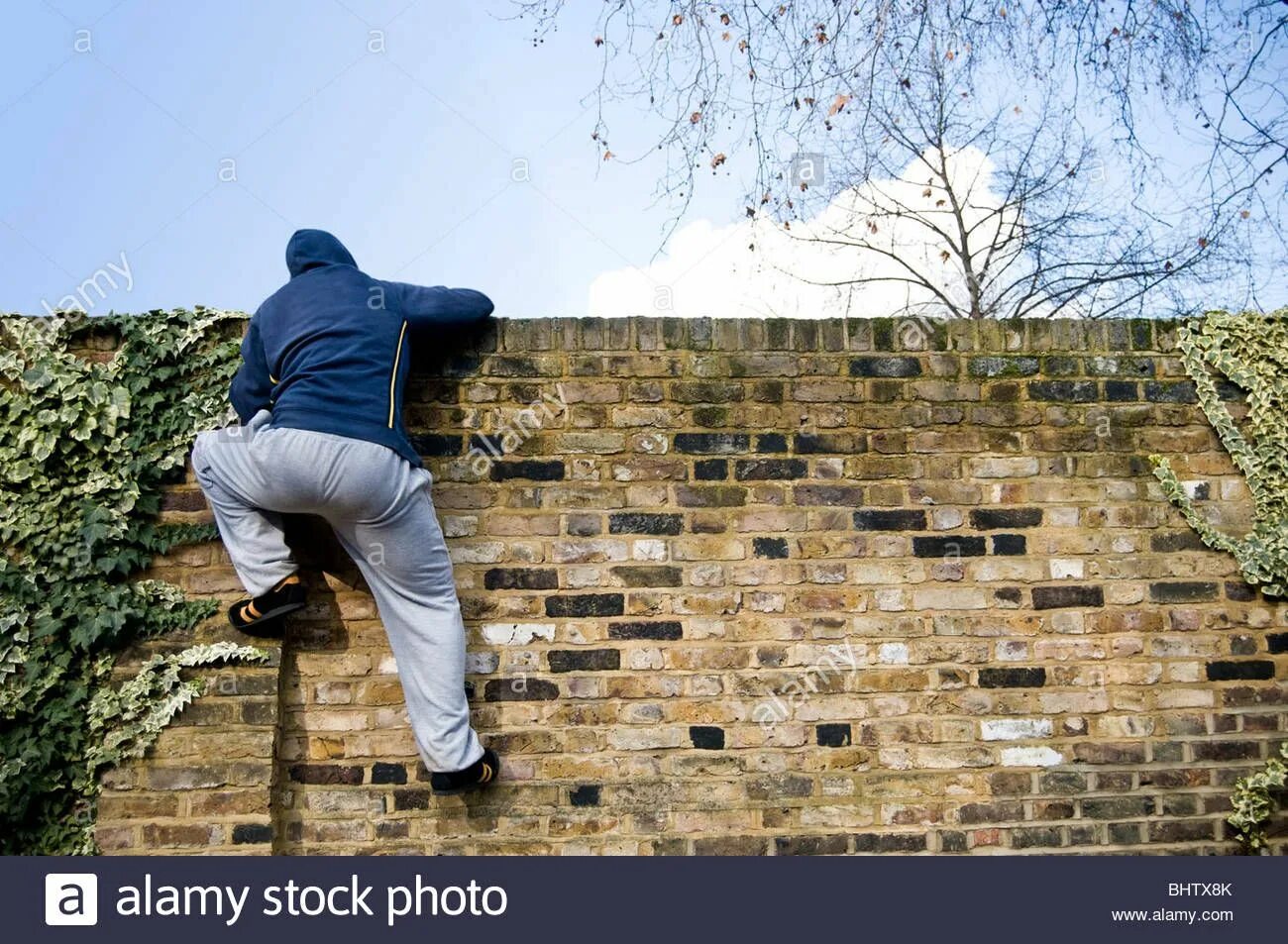 Стеной через тело. Перелазит через стену. Мужчина перелезает стену. Man Climbing the Wall. Climb over the Wall.