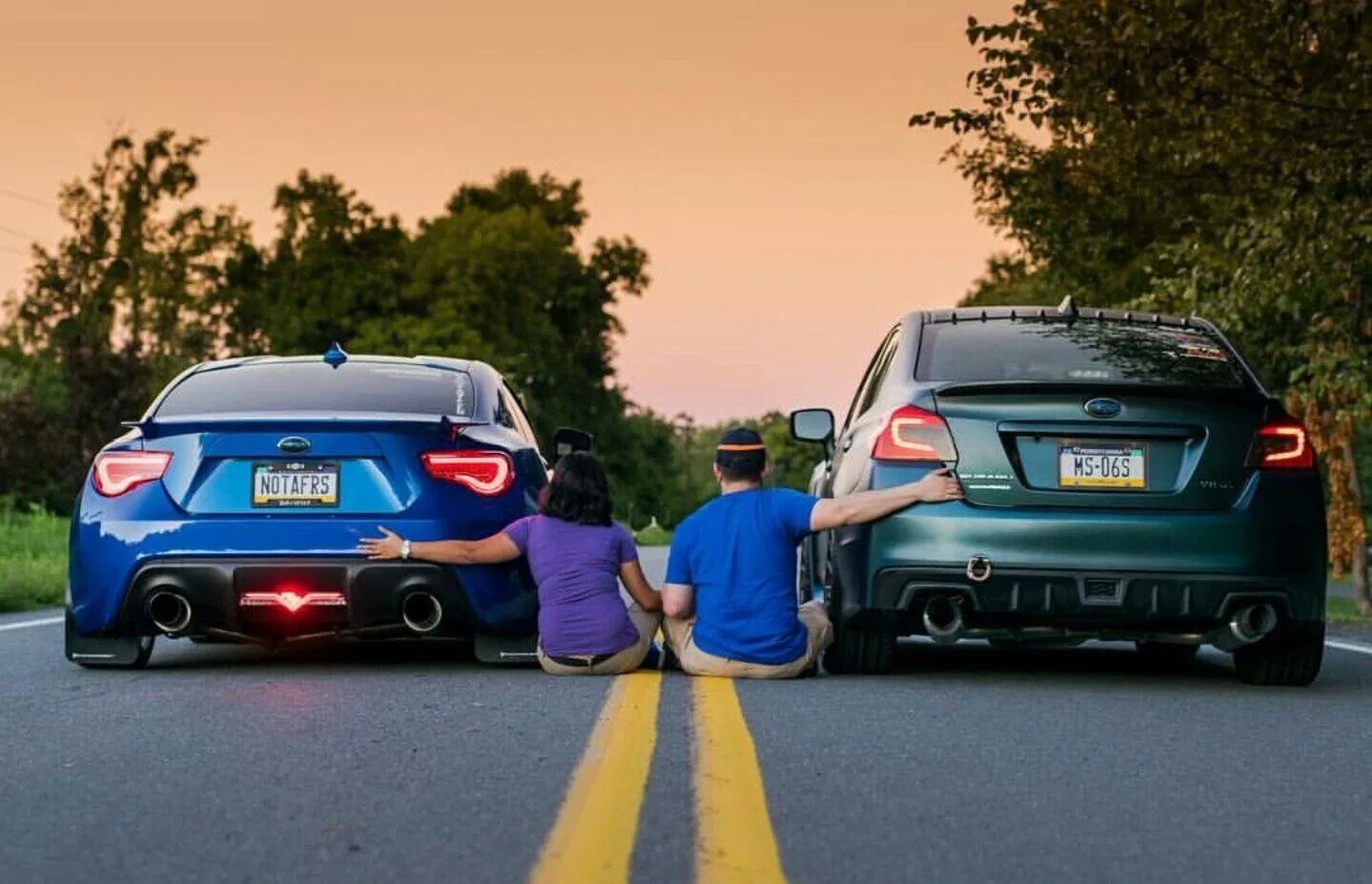 обнимает автомобиль. фотосессия с двумя машинами. любимый автомобиль. двое около машины. ругаются в автомобиле.