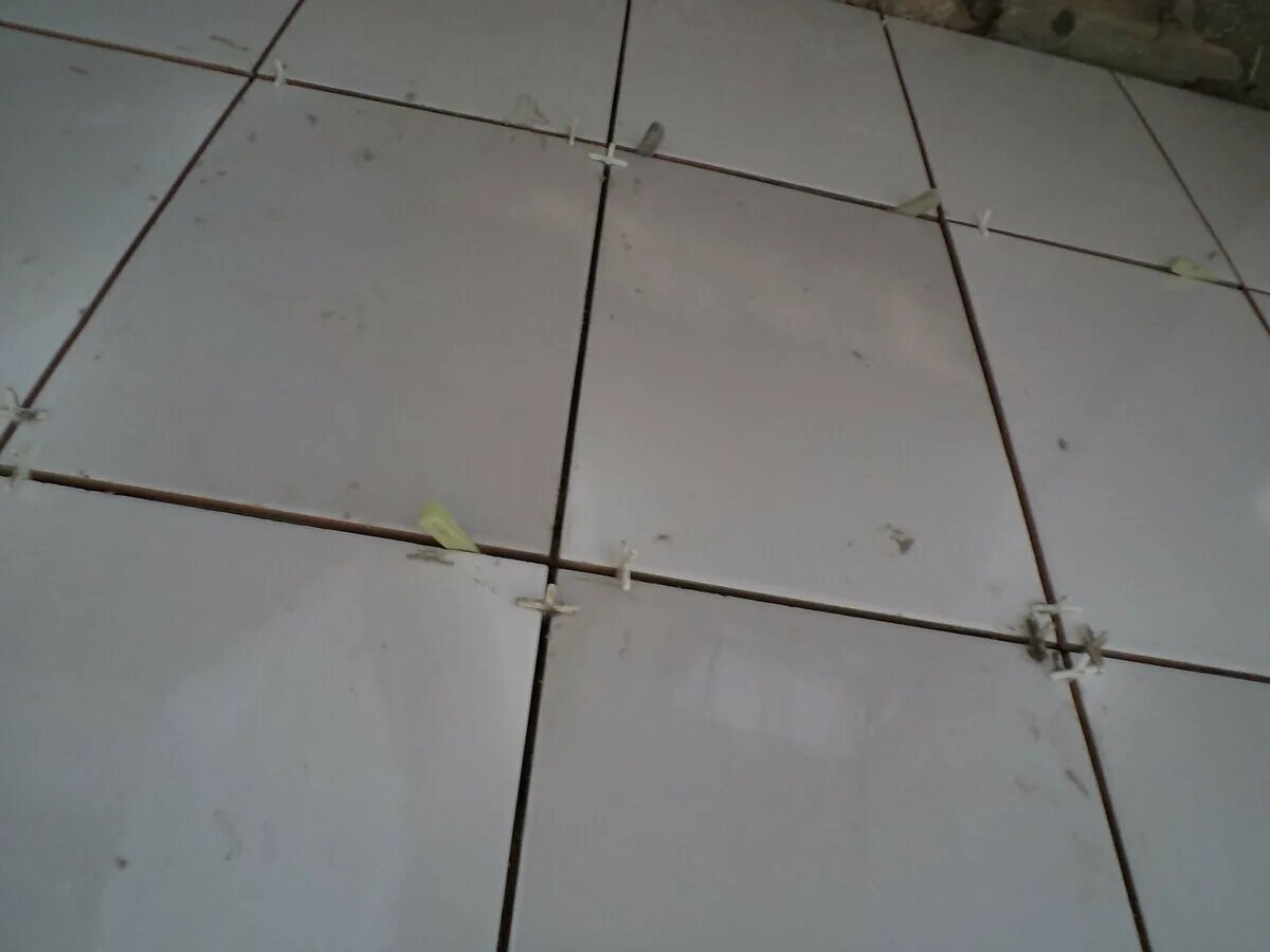Неровно положенная плитка на полу. Укладка напольной плитки. Швы плитки. Затирка швов на плитке в ванной. Неровно положенная плитка.
