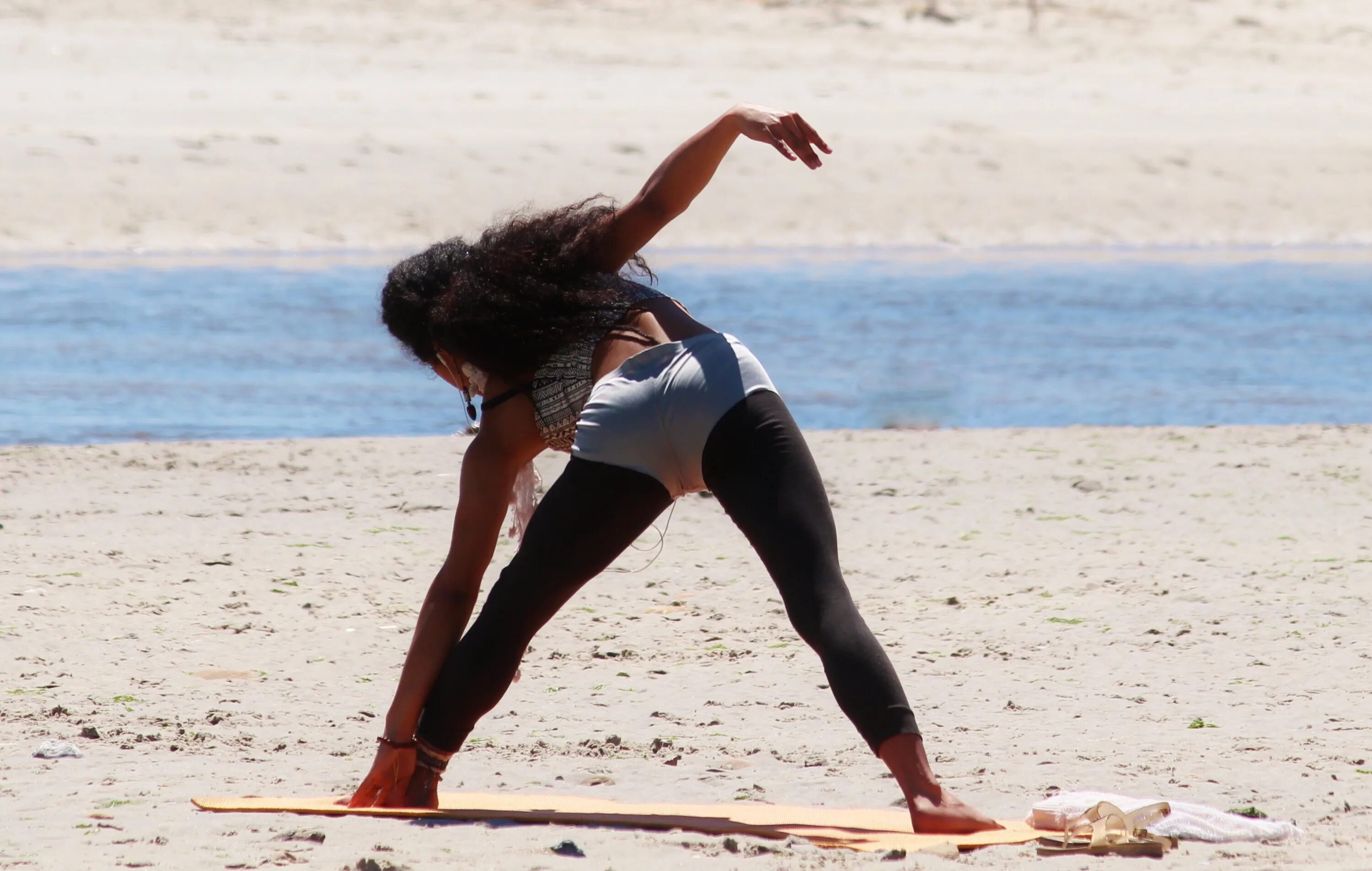 Девушка йога. Баба йога. Гимнастика на пляже. Женщина прыгающая на песке.