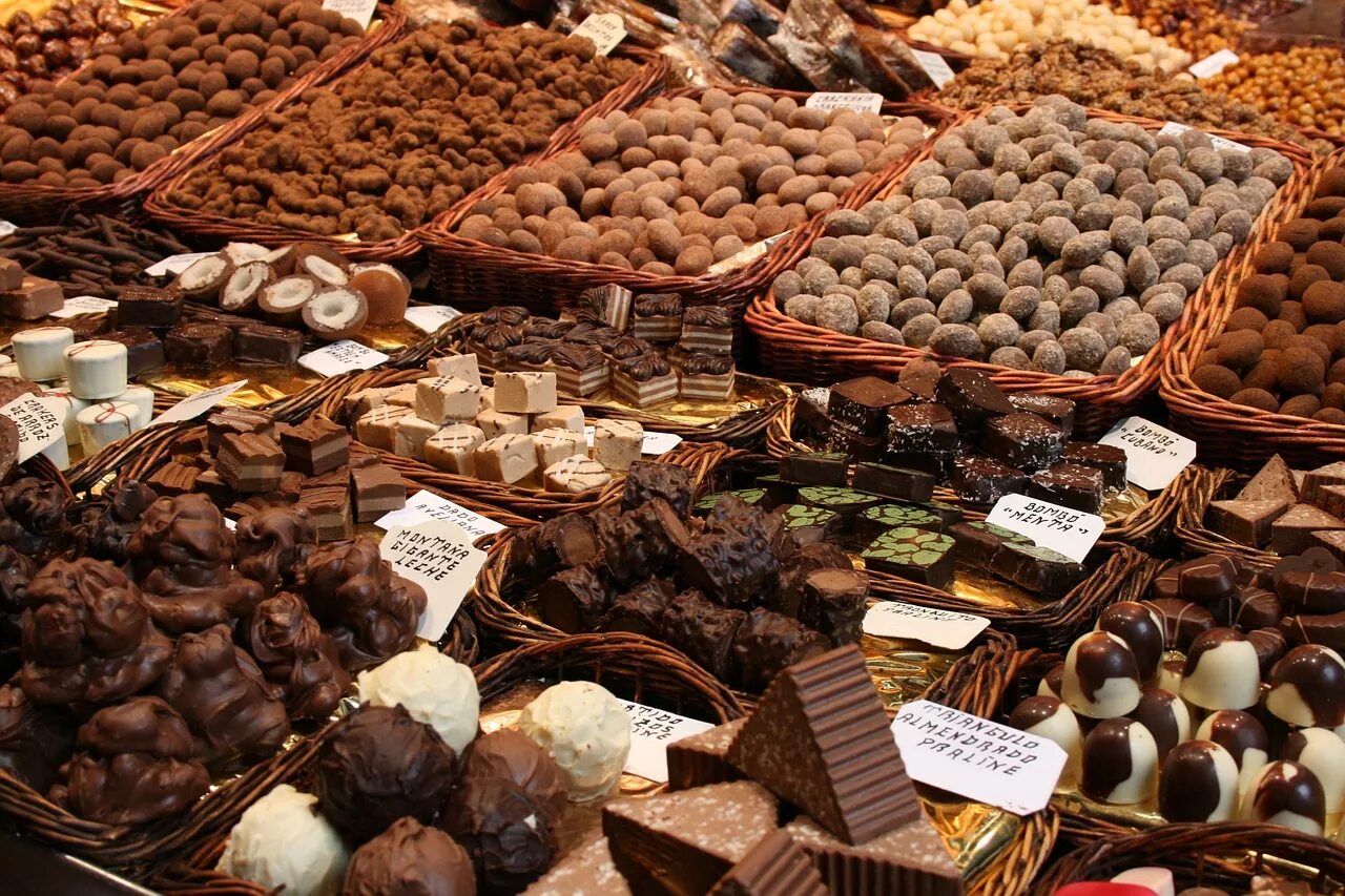 История сладостей. Шоколадные конфеты. Шоколадные сладости. Конфеты на рынке. Гора шоколадных конфет.
