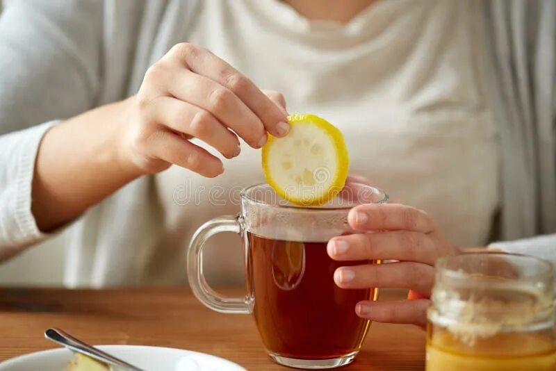 Выпить чаю лимоном. Пьет чай с лимоном. Девушка чашка чая и лимон. Лимон с чаем. Кружка чая с лимоном в руке женщины.