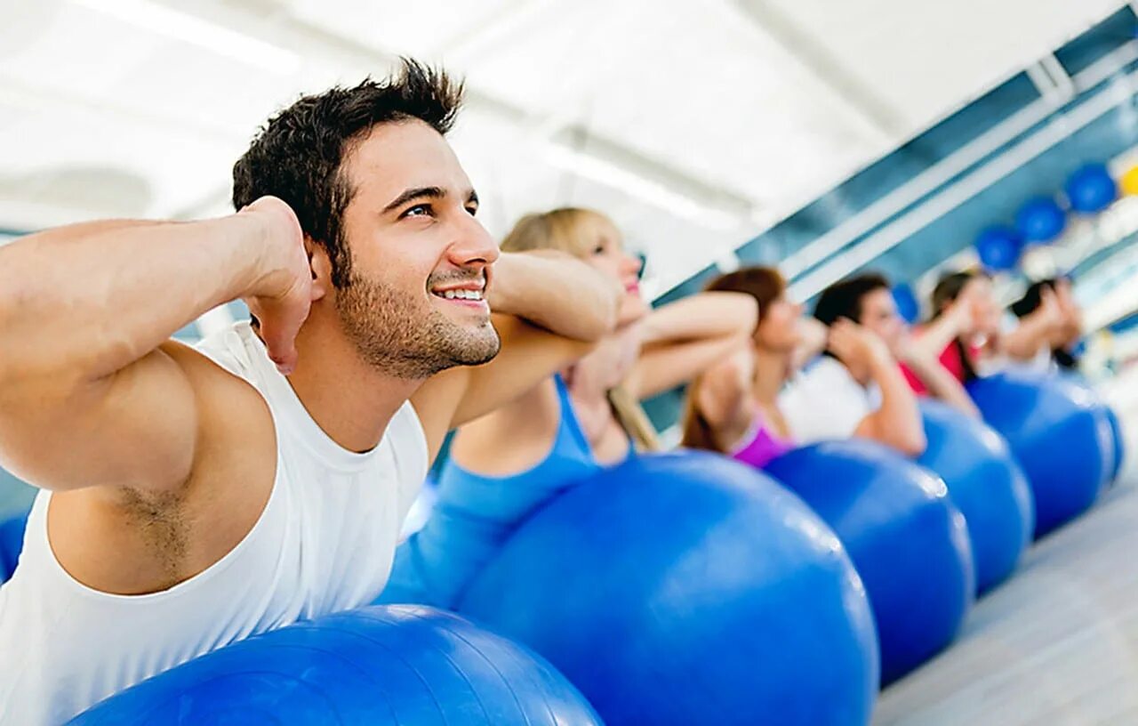 занимайтесь спортом друзья. спортивные люди. человек занимающийся городками. пожилые люди в спортзале. спортзал.