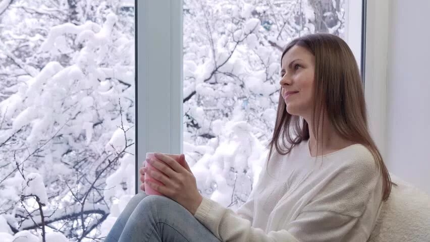Девушка у окна зима. Девушка за шторой. Девушка пьет кофе у открытого окна. За окном девочка в бежевом клип. За окном девушка в бежевом клип.