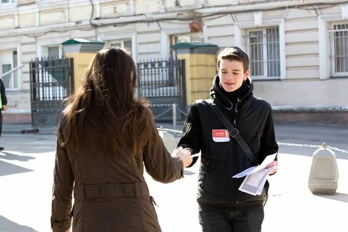 Как называются люди раздающие листовки на улице. Парень раздает листовки. промоутер листовки. промоутер парень. раздают листовки на улице.