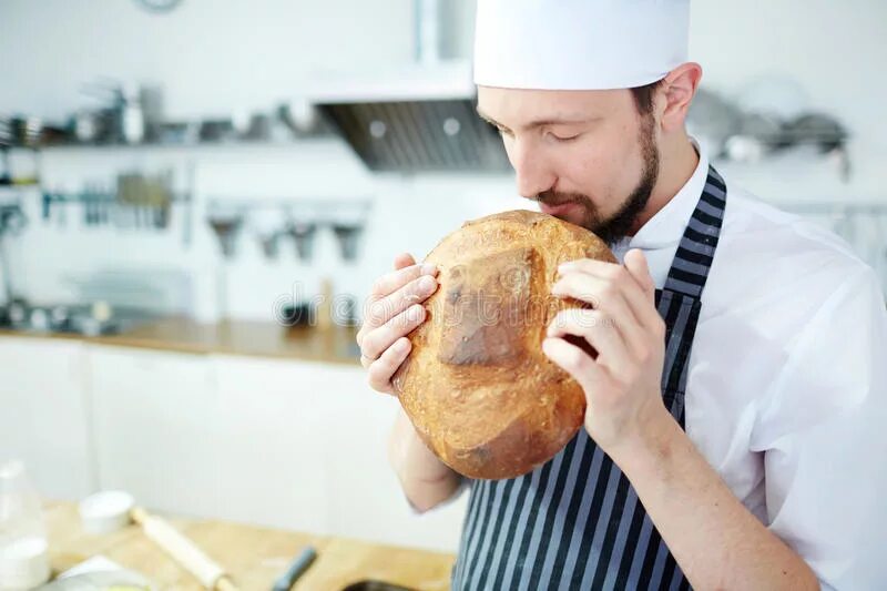 Человек есть хлеб. Запах хлеба. Аромат хлеба. Пекарь аромат хлеба. Нюхает хлеб.