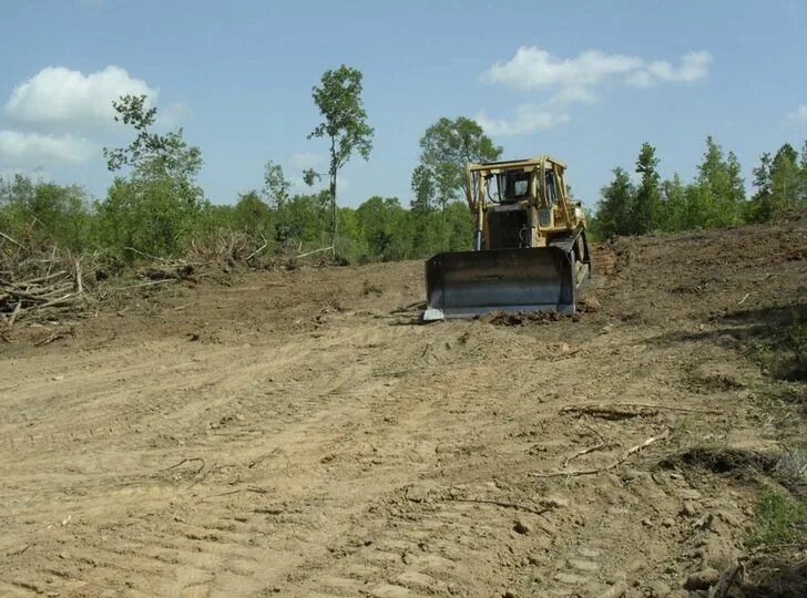Clearing land. Clearing wooded Land with Anchor Chain and Bulldozer.