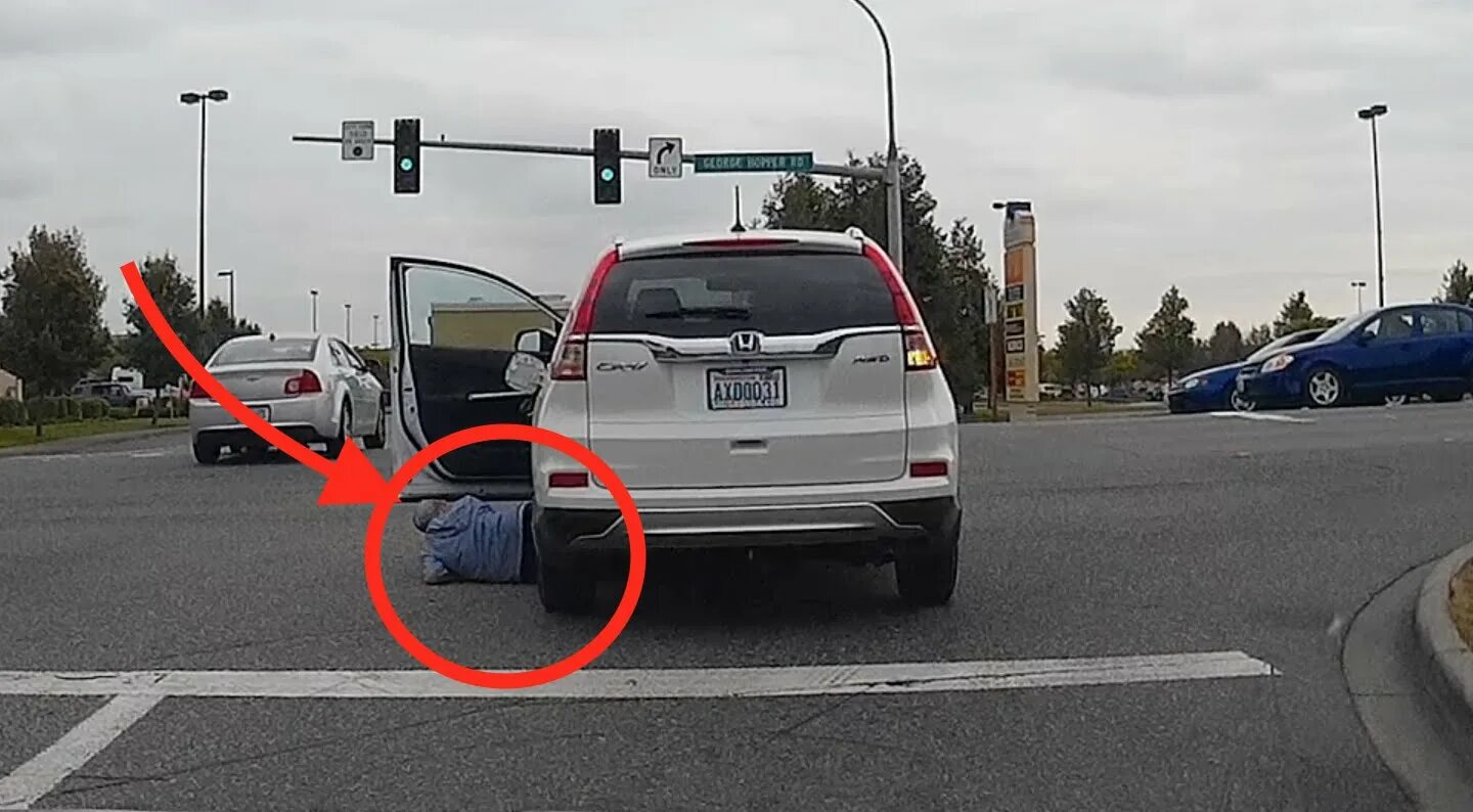 Леди покидающая автомобиль увеличивает его скорость. Car stopped at an intersection pieton.