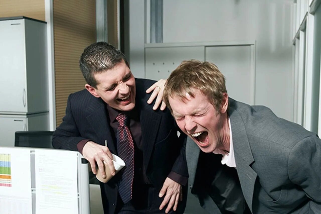 Как шутить с друзьями. Два человека смеются. Люди смеются в офисе. Два парня смеются. Друзья смеются над другом.