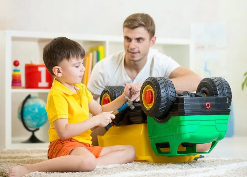 Toying with dad. Папа починил детям игрушку. парень играет с игрушками-аналогами. boy playing with toys. little boy and father play toy.