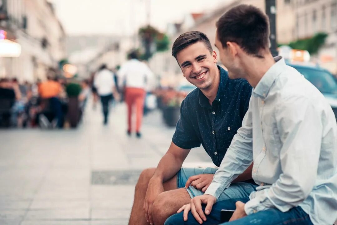 Two young men. Два мужчины разговаривают на улице. Друзья парни. Мужчины разговаривают на улице. Двое мужчин беседуют.