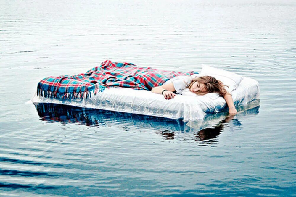 Человек плывет по реке. Фотосессия на матрасе на воде. Кровать на воде. Плавают на матрасе. Матрас на воде.