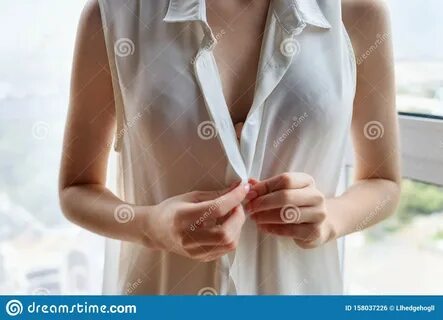 Photo about Unrecognizable woman unbuttoning white blouse at home. 