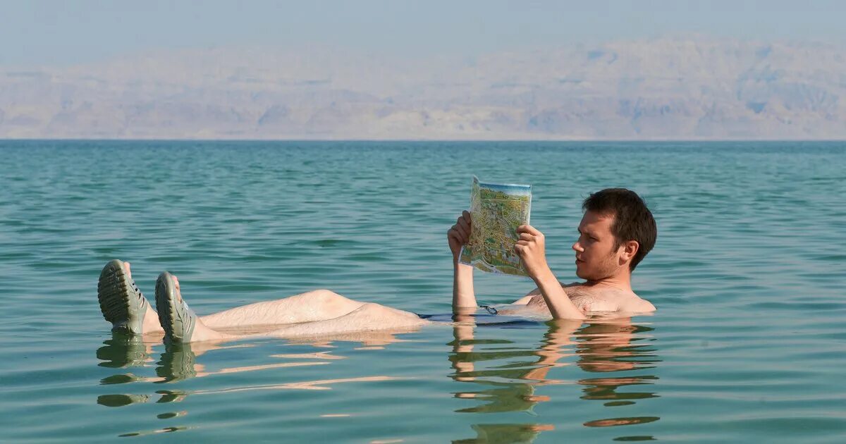 Мертвое море человек на воде. Мертвое море люди плавают. Мертвое море люди. Мёртвое море люди сидят на воде.