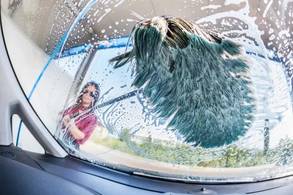 Мытье стекол машины. Лобовое стекло. Арка лобового стекла. Девушка моет лобовое стекло. Мойка автомобилей вид внутри.