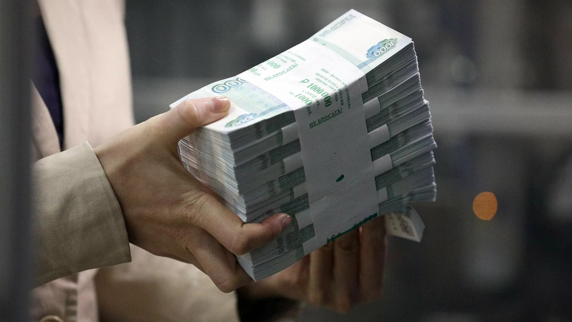 Пачка денег. Деньги. Наличка в руках. Рука протягивает деньги. Получение большой суммы денег.