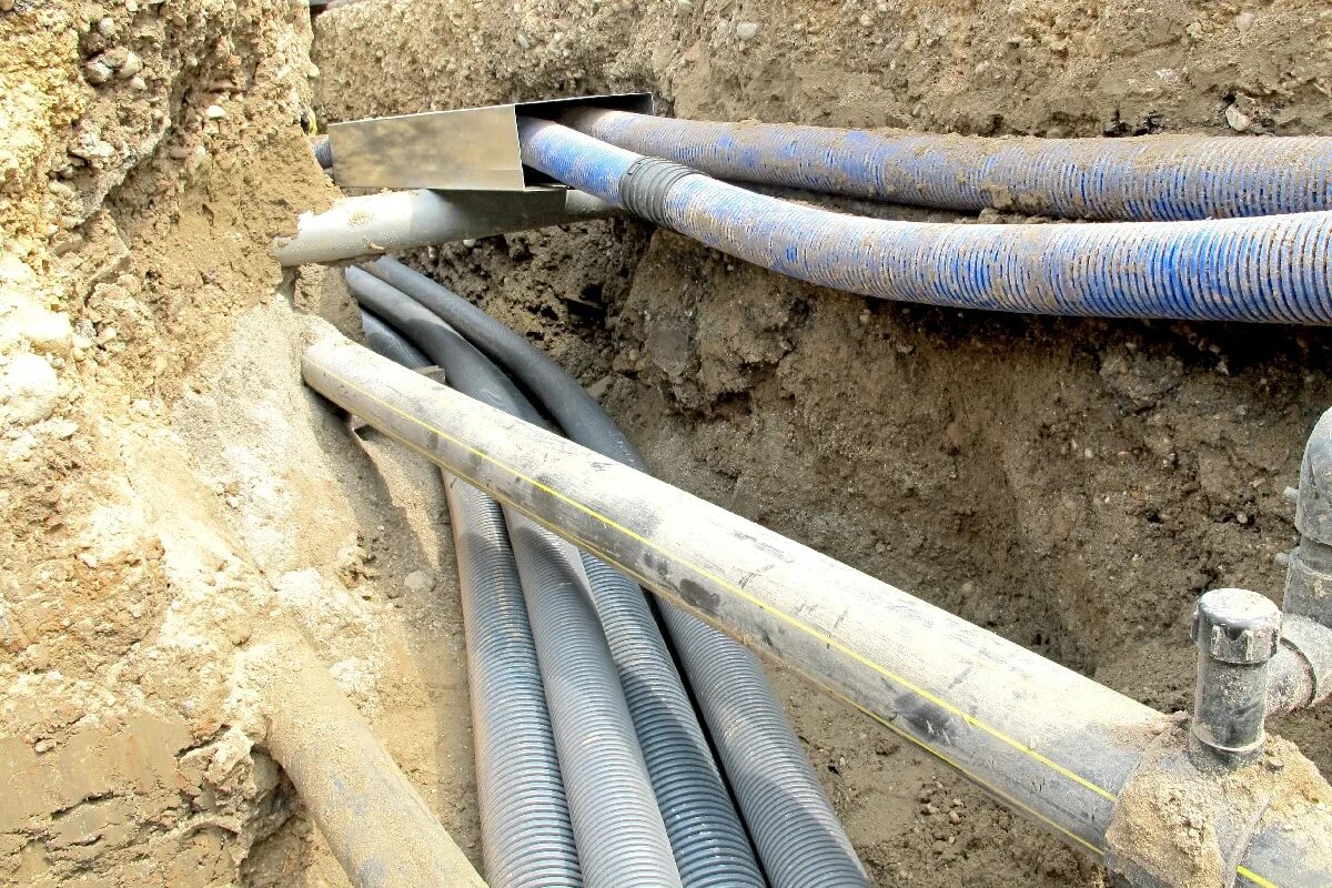 Водопровод технология. Труба для прокладки кабеля под землей. Труба в земле. Укладка водопроводной трубы в траншею. Трубы под землей.